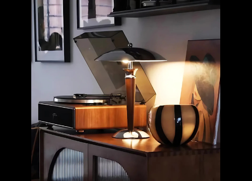 Une lampe bauhaus déposée sur meuble aux côtés d'un lecteur vinyle