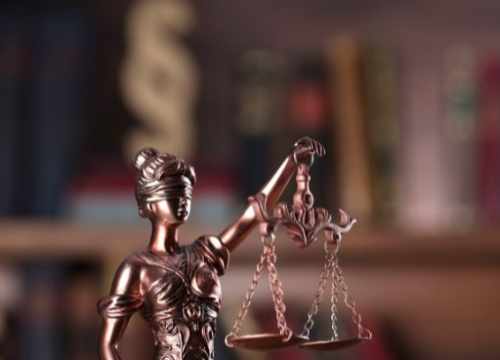 Une réprésentation d'une statue de la justice portant des plateaux et ayant les yeux bandés