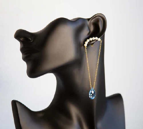 Photo représentant trois paires de boucles d'oreilles, des paires dorées et une paire avec des perles et des gemmes améthyste