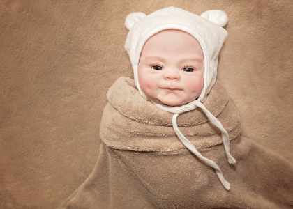 Ce bébé reborn porte un bonnet ourson.