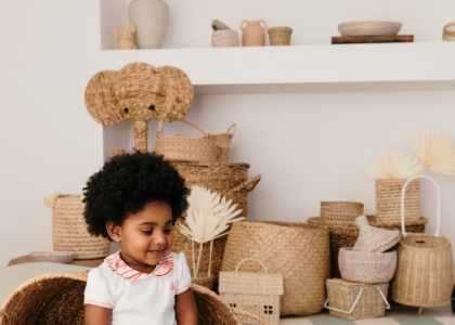 Deux bébés portant des tenues Bobo Bassari : l'un assis avec le body bébé col imprimé Bandia, l'autre allongé dans un panier en rotin, entouré d'une ambiance chaleureuse et naturelle