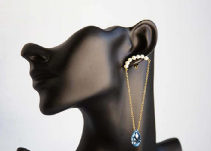 Photo représentant trois paires de boucles d'oreilles, des paires dorées et une paire avec des perles et des gemmes améthyste