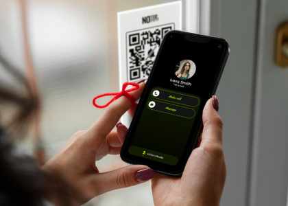 Une femme utilise No-Bell. Elle scan le code QR devant la porte pour sonner 